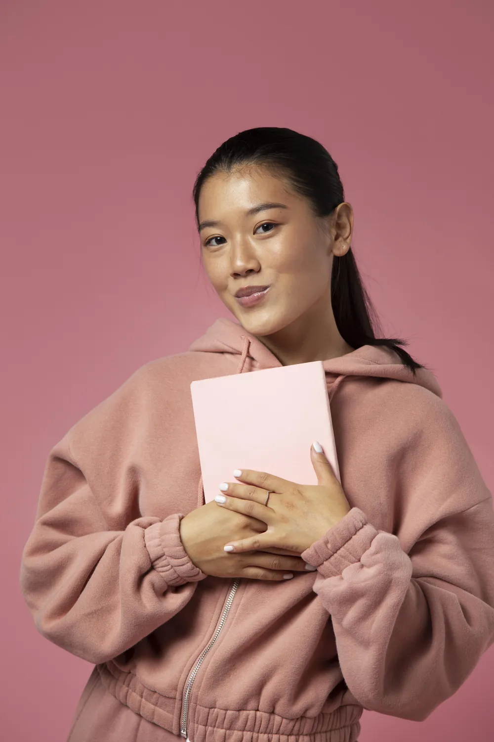 A smiling learner holding a notebook